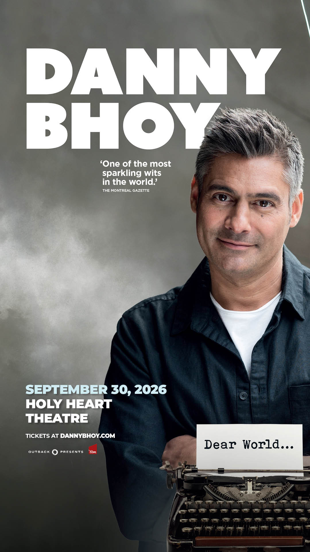 Promotional poster featuring a man with short gray hair in a dark button-up shirt, seated beside a vintage typewriter holding a sheet that reads “Dear World…”. Large text at top: “DANNY BHOY.” Quote: “One of the most sparkling wits in the world.” Event details: “September 30, 2026, Holy Heart Theatre.” Tickets at dannybhoy.com. Gray background with Outback Presents and TIX logos.